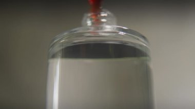 Parfümcü cam bir şişenin içine yağlı koku damlaları döküyor. Portakal özü ve parfüm kokusu kullanarak nefis bir koku yaratma süreci..
