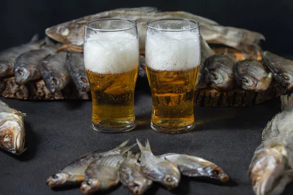 Alkolik, kurutulmuş balıkla bira içer.