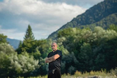 Arkasında dağlar olan güçlü bir adam.