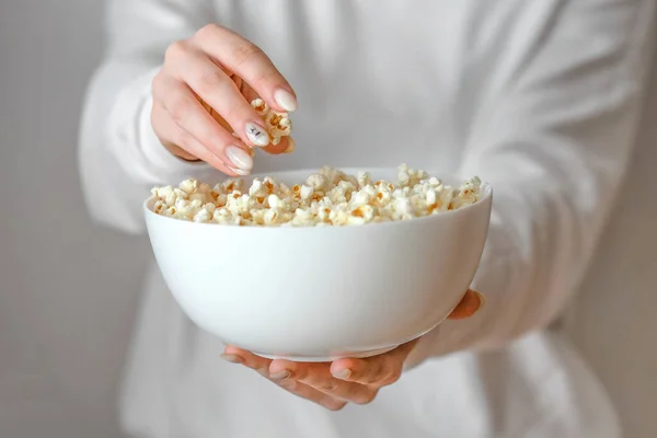 Herstellen von Popcorn zu Hause, ein Teenager-Mädchen hält eine große Tasse mit Fertigpopcorn in der Hand — Stockfoto