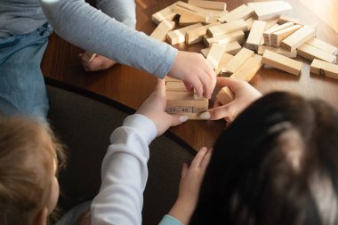 Çocuklar evde Jenga çubuklarıyla oyun oynuyorlar.