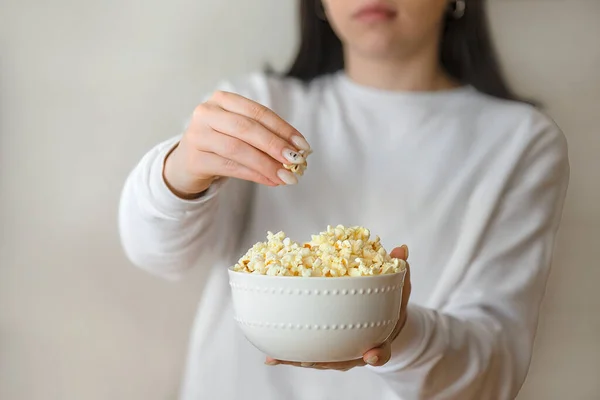 Popcornt készítek otthon, egy tinédzser lány kezében egy nagy csésze kész popcornnal. — Stock Fotó