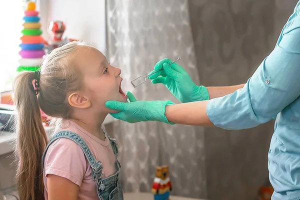 Dil terapisi masajı. Konuşma terapisti bir kıza dil masajı yapar.