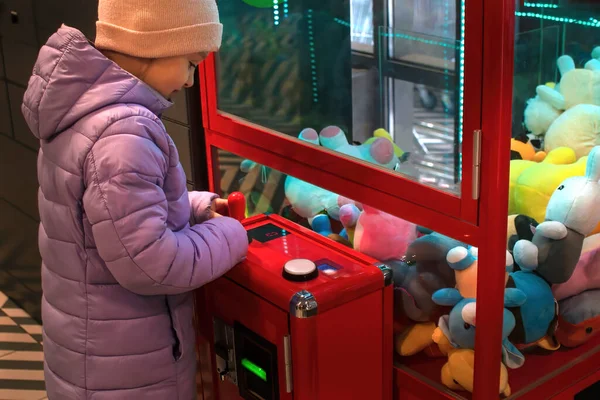 Kind, meisje spelen in een machine met zacht speelgoed — Stockfoto