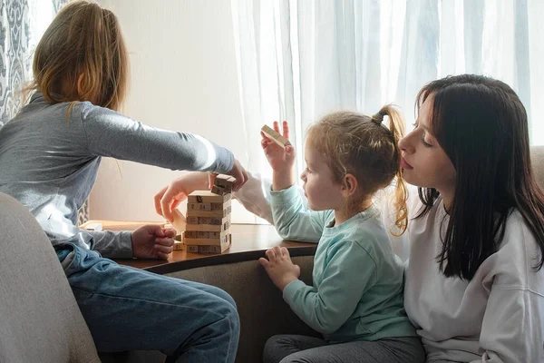 Çocuklar evlerinde tahta sopalarla masa oyunu oynuyorlar.