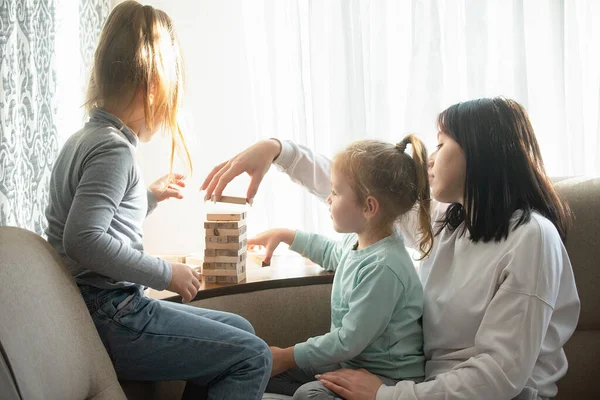 Çocuklar evlerinde tahta sopalarla masa oyunu oynuyorlar.