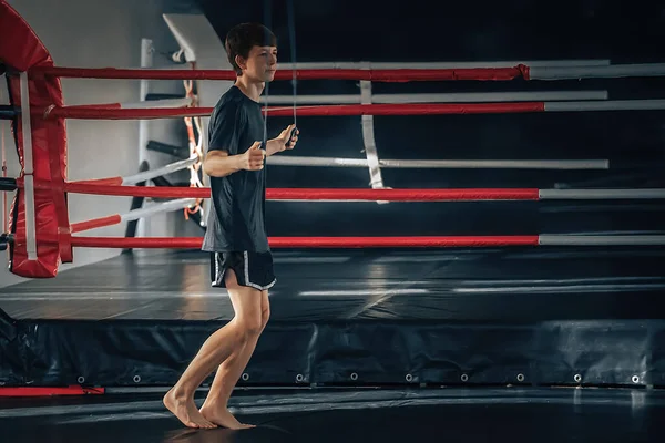 Teenager goes in for sports from the gym, jumping rope during warm-up — Fotografia de Stock