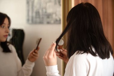 A young girl is very surprised that her hair is falling out