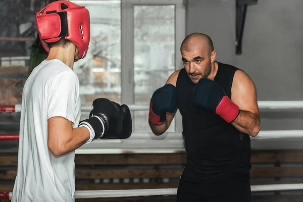 Treinador e boxeador adolescente fazendo um treino no ginásio — Fotografia de Stock