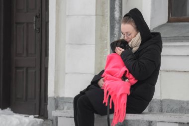 Alman bir boksör yavrusuyla birlikte kış yürüyüşüne çıkmış güzel bir genç kadının portresi.