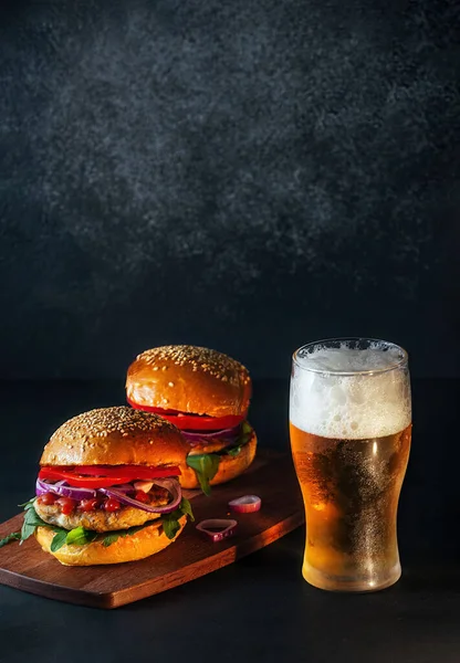 Bir bardak köpüklü alkolik bira ve hamburger iç.