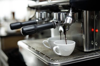 Kahve makinesi espressoları beyaz bardakta.