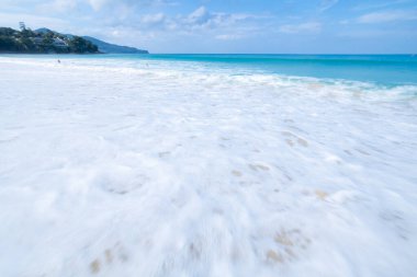 Deniz dalgası kumsaldaki kumlara beyaz köpük yayar Phuket Denizi Tayland geniş açılı düşük açılı deklanşör görüntüsü