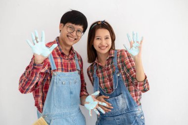 Yom-bear ve ekose gömlekli genç Asyalı çift Tayland 'da yeni bir renge boyamaya yardım ediyor.
