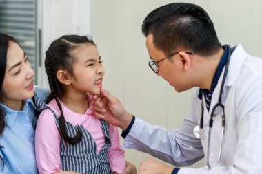 Diş hekimi Tayland 'daki küçük Asyalı kızın dişlerini inceliyor. 