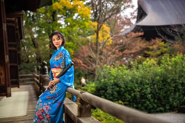 日本の秋の公園で日本の青い着物と傘を手にしたアジアの女性の肖像 — ストック写真