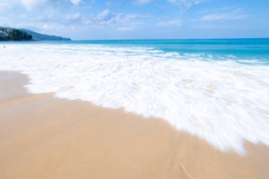 Deniz dalgası kumsaldaki kumlara beyaz köpük yayar Phuket Denizi Tayland geniş açılı düşük açılı deklanşör görüntüsü