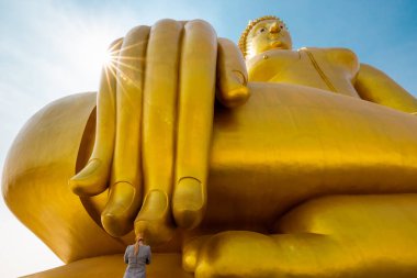 Genç bayan turistler Tayland 'daki büyük Buda' nın parmaklarına saygılarını sunuyorlar. 