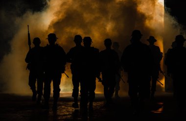 Siluet Tayland askerleri özel kuvvetler tam üniformalı. Dumandan yürüyorlar ve arka planda silah tutuyorlar.