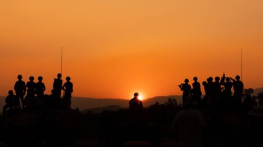 Siluet ve gündoğumunda arka planda top askerler Tayland 'da silah tutuyorlar.