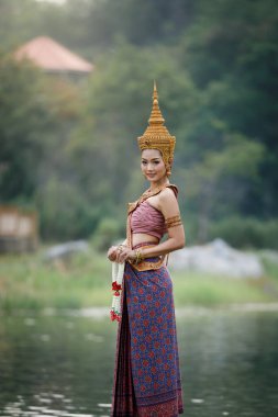 Bahçede geleneksel Thai kırmızı, mor ve altın mücevherler takan bir portre modeli