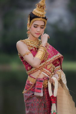Bahçede geleneksel Tayland kırmızı ve altın mücevherleri takan portre modeli