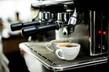 Kahve makinesi espressoları beyaz bardakta.