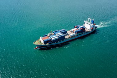 aerial view in front container ship full speed in green sea, business and industry transportation import export international by container ship open sea horizon and blue sky background 
