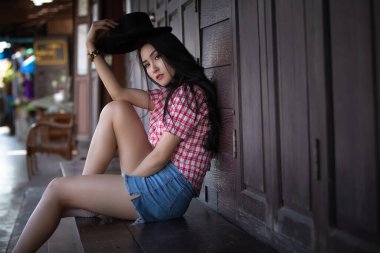 Ekose gömlekli, kısa pantolonlu ve kovboy şapkalı bir modelimiz var.