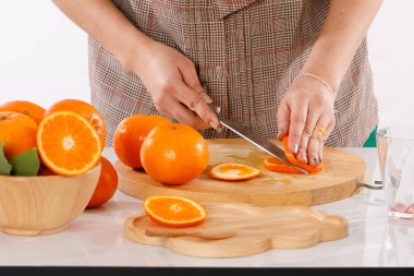 Kız portakal, meyve suyu, meyve blender, kovan sürahiler ve beyaz arka plan ışık stüdyosu olan ahşap kaplar gibi malzemelerle meyve suyu yapmayı öğreniyordu.