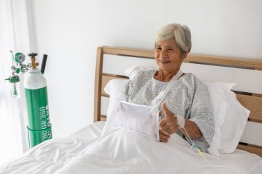 Kırık yaşlı hasta kadın hastanede el ele tutuşuyor.