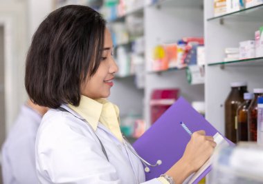 Kadın eczaneler mağazadaki mevcut uyuşturucuları kontrol ediyorlar Asyalı kadınlar ve eczane konsepti