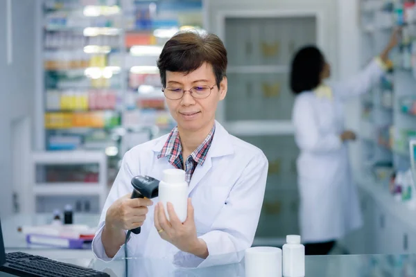 Junge Asiatische Apothekerin Scannt Barcodes Auf Weißer Medizinflasche Und Bearbeitet — Stockfoto