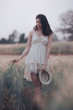 Doğal ışık portresi güzel Asyalı kadın gelinliği ve yürüyüş için kulübe Chiang Mai Tayland 'daki tarımsal arpa pirinç tarlalarında rahatla, yalnız doğa insanları klasik tarz ton kavramını benimsiyor. 