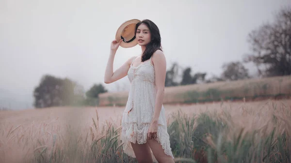在泰国昌麦的农业大麦田里 穿着婚纱和小木屋散步的美丽的亚洲女人 独自享受大自然赋予她们的古老气息 — 图库照片