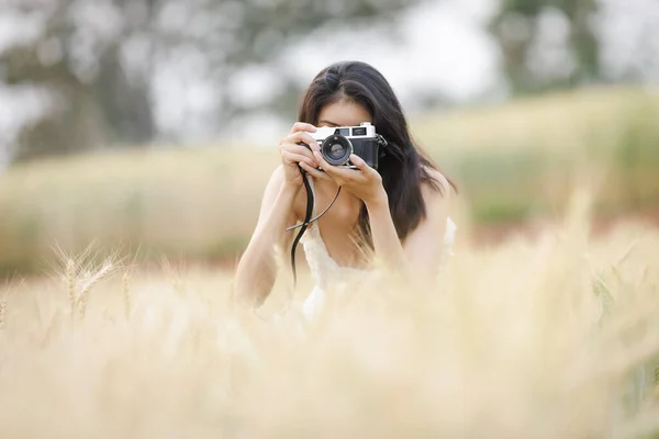 young tourist using camera to shoot barley rice farm relaxation summer holiday concept