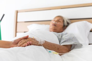 Asyalı yaşlı hasta Tayland 'da hastane odasında oksijen ve tuz solüsyonu ile uyuyor.