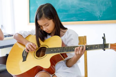 Kapalı Asyalı Kız Müzik Sınıfında Gitar Çalıyor Yazın Mekan Konsepti 