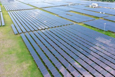 Çiftlikteki çatıdaki güneş panelleri veya güneş pillerinin havadan görüntüsü. Yeşil alana sahip enerji santrali, Tayland 'da yenilenebilir enerji kaynağı