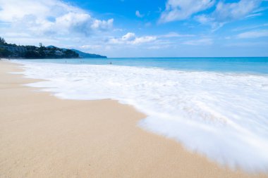 Deniz dalgası kumsaldaki kumlara beyaz köpük yayar Phuket Denizi Tayland geniş açılı düşük açılı deklanşör görüntüsü