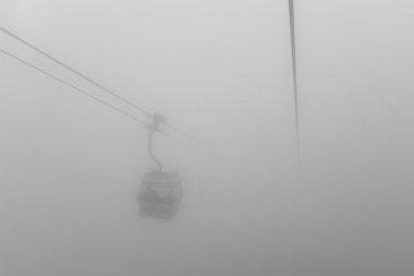 Yağmur mevsiminde dağda teleferik ve Hong Kong porselenlerini sis kaplıyor.