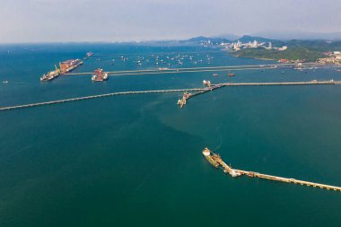 Deniz manzarası ve petrol istasyonu köprüsü, insansız hava aracından yeşil deniz manzarası üzerinde yelkenli petrol ve gaz. 