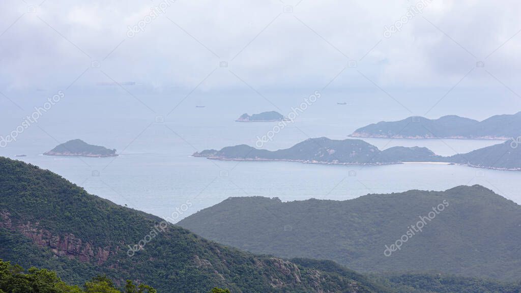 landscape and seascape mountain and the sea and shipping cargo containers in the rain season at viewpoint ngong ping 360 cable car in hong kong asia travel tourist concept