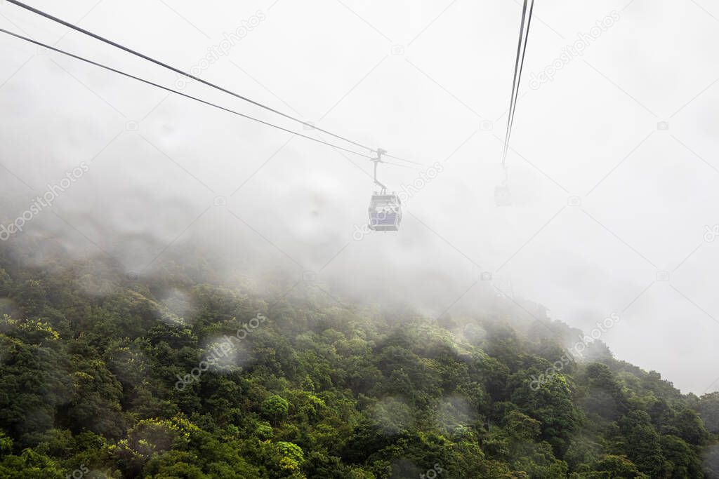 ngong ping 360 cable car and rain drop foreground on the green mountain landscape view in the rain season hong Kong aerial view