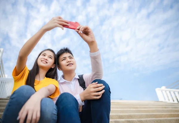 ティーン男の子と女の子アジアタイ手セルフィーを保持し スマートフォン技術に笑みを浮かべて — ストック写真