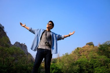 Portre açısı: Turist fotoğrafları. Kollar ve dağ yeşili orman. Mavi gökyüzü arka plan özgürlük adam kavramı.