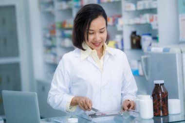 Eczane Tayland 'da plastik içinde satılık Asyalı kadın eczacı ilaçları. 