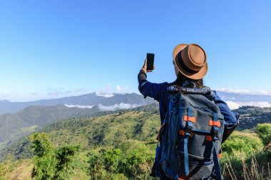Genç Asyalı sırt çantalı turistler sinyali ve haritayı kontrol ediyorlar dağdaki ve dağdaki sisli arka planda Doi Chiang Mai Tayland 'da