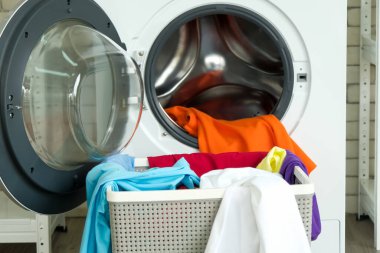 Modern çamaşır makinesi ve çamaşır sepetinin olduğu ev çamaşırhanesi. 