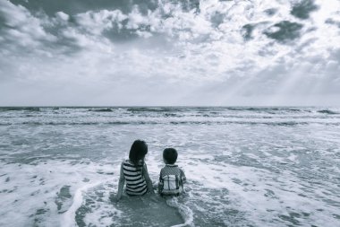 Sahilde oturan kız ve oğlan duygularını aktarıyor. Yalnız siyah beyaz fotoğraf sanatı.